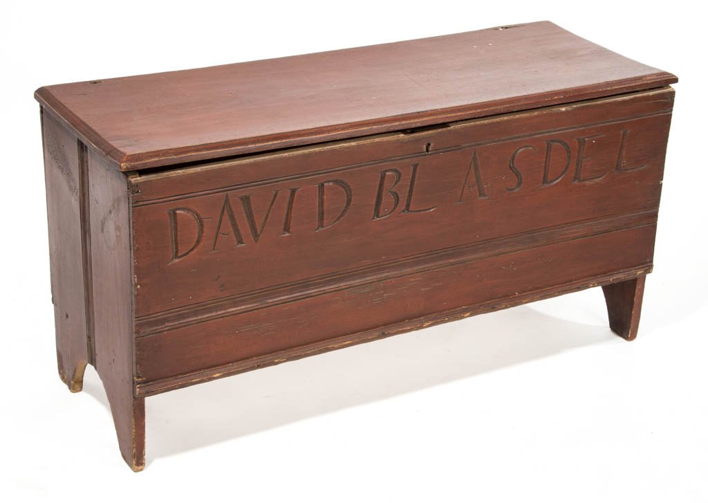 NEW ENGLAND CARVED AND PAINTED BLANKET CHEST: NEW ENGLAND CARVED AND PAINTED BLANKET CHEST, the hinged rectangular lid over a nailed case raised on straight sides with cut-out bootjack ends. Later carved name to front "David Blasdell". Old red-pa