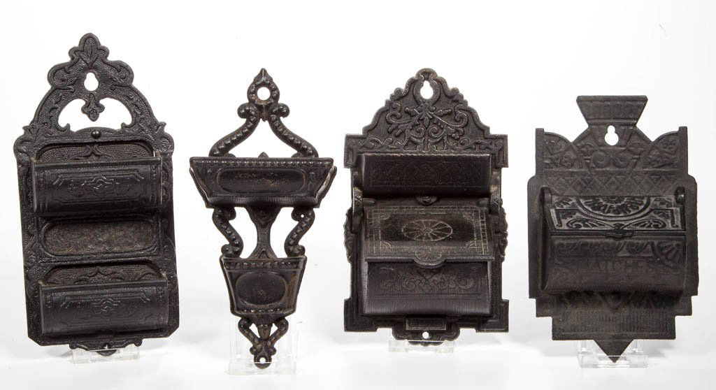 ASSORTED FIGURAL CAST-IRON MATCH HOLDERS / SAFES, LOT: ASSORTED FIGURAL CAST-IRON MATCH HOLDERS / SAFES, LOT OF FOUR, wall mounts, each with various scroll ornamentation and striker feature, comprising three examples with double pockets, including an exam