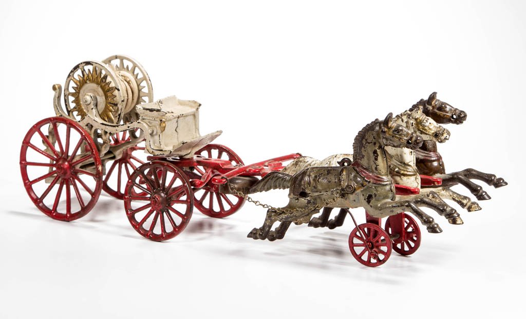 HORSE-DRAWN FIRE-HOSE REEL CAST-IRON TOY WAGON: HORSE-DRAWN FIRE-HOSE REEL CAST-IRON TOY WAGON, with three horses, of which the outside two "gallop" when the wagon is rolled, and bell under harness shaft. Original paint. Probably Dent Hardware. Fou