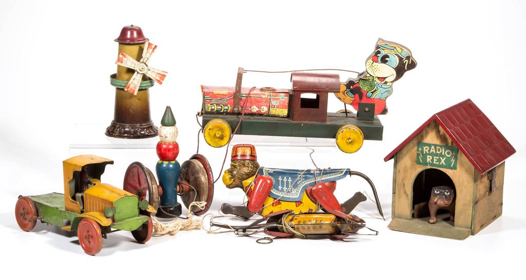 ASSORTED TIN AND WOOD TOYS, LOT OF SEVEN: ASSORTED TIN AND WOOD TOYS, LOT OF SEVEN, including Radio Rex with celluloid bulldog, and two climbing monkeys, one Marx. 20th century. Various sizes. Provenance: From the Ed & Kay Winnick collection,