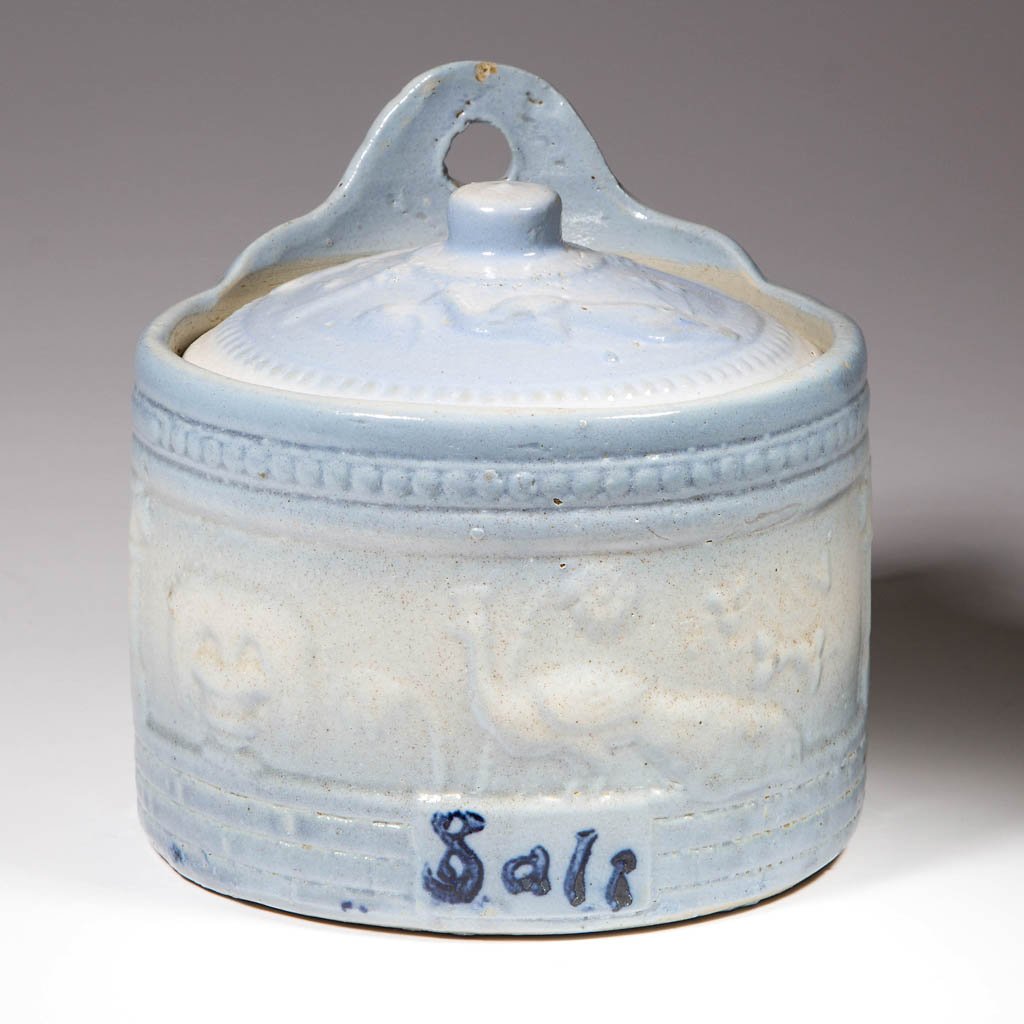 BLUE AND WHITE SALT-GLAZE CERAMIC SALT HOLDER WITH: BLUE AND WHITE SALT-GLAZE CERAMIC SALT HOLDER WITH COVER, in the Peacock pattern. First quarter 20th century. 6" HOA, 6" D. Literature: Taylor/Lowrance - Salt Glaze Stoneware, pp. 134, 135. Provenance