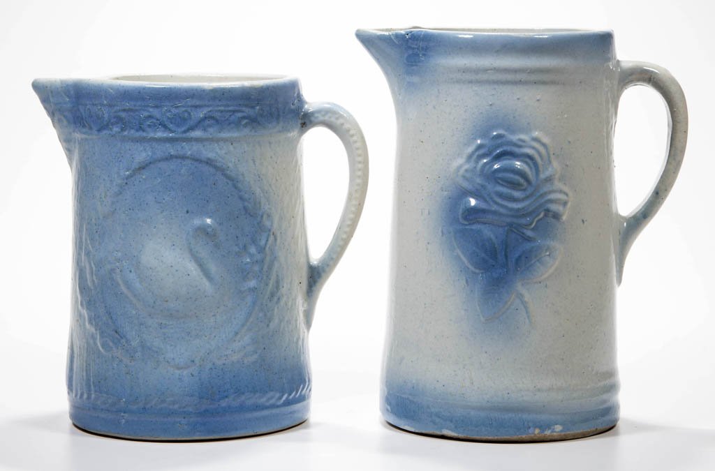 BLUE AND WHITE SALT-GLAZED CERAMIC PITCHERS, LOT OF TWO: BLUE AND WHITE SALT-GLAZED CERAMIC PITCHERS, LOT OF TWO, comprising Garden Rose and Swan patterns. First quarter 20th century. 8 1/8" and 9 1/8" HOA. Literature: Taylor/Lowrance - Salt Glaze Stoneware