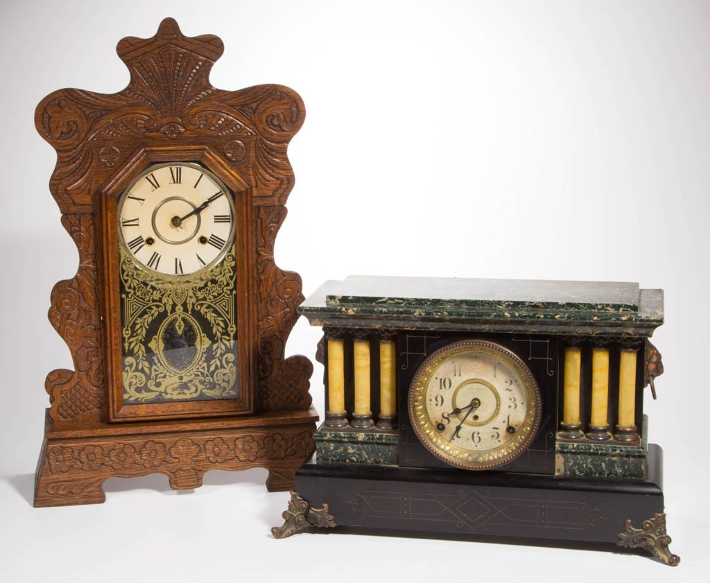 LATE VICTORIAN MANTLE CLOCKS, LOT OF TWO: LATE VICTORIAN MANTLE CLOCKS, LOT OF TWO, comprising an unmarked oak kitchen clock with pressed decorations, and a Seth Thomas column style with original faux-marble decorations and lion-mask handles,
