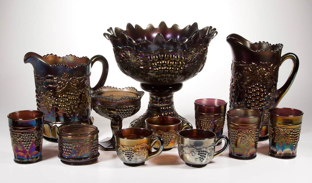 NORTHWOOD "GRAPE AND CABLE" CARNIVAL GLASS TABLE: NORTHWOOD "GRAPE AND CABLE" CARNIVAL GLASS TABLE ARTICLES, LOT OF 13, light to dark amethyst/purple iridescent, comprising four tumblers, three punch cups, punch bowl with pedestal base, a tankard and