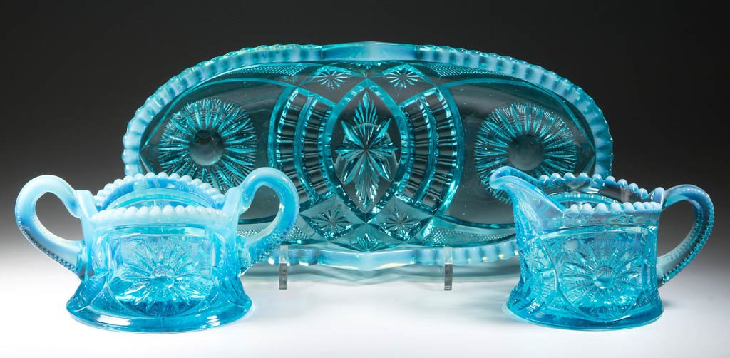 DIADEM (OMN) / SUNBURST-ON-SHIELD TABLE ARTICLES, LOT: DIADEM (OMN) / SUNBURST-ON-SHIELD TABLE ARTICLES, LOT OF THREE, blue opalescent, comprising a celery tray, breakfast creamer, and a breakfast sugar. H. Northwood & Co. Circa 1905. Creamer 3" HOA, cele
