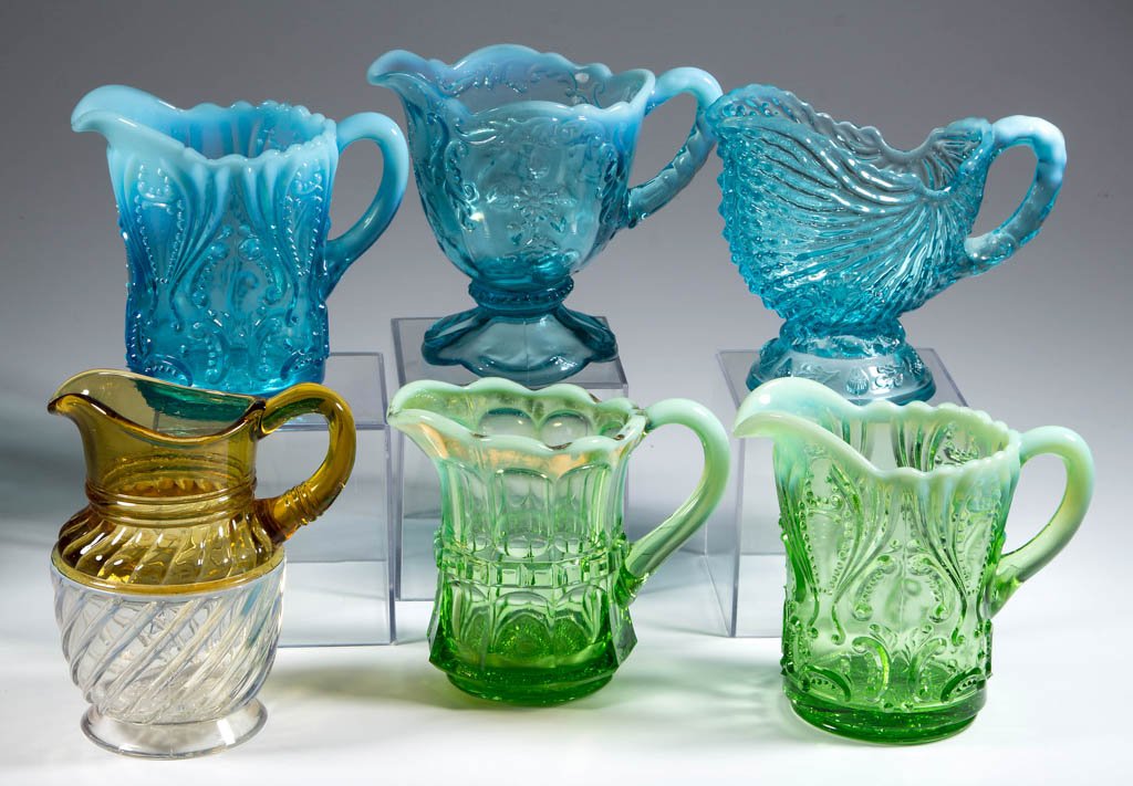 ASSORTED PRESSED OPALESCENT CREAMERS, LOT OF SIX: ASSORTED PRESSED OPALESCENT CREAMERS, LOT OF SIX, colorless, blue, and green opalescent, comprising Adonis/Gonterman Swirl with amber top, Argonaut Shell signed "Northwood," two Idyll, Intaglio, and a