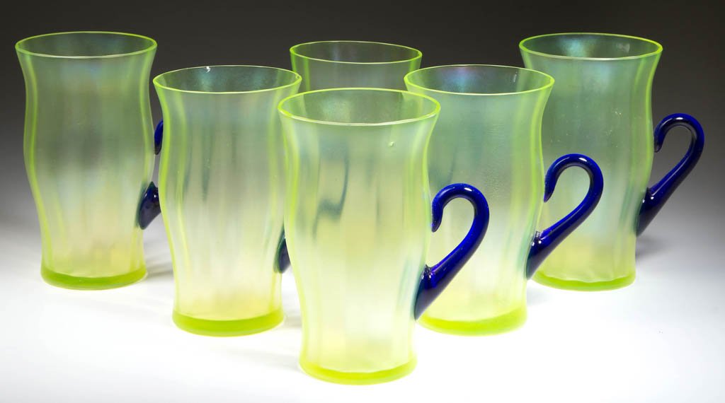FENTON STRETCH GLASS ICED TEA TUMBLERS, LOT OF SIX: FENTON STRETCH GLASS ICED TEA TUMBLERS, LOT OF SIX, Topaz/vaseline (uranium) iridescent, each with a factory polished rim and applied cobalt blue handle. Fenton Art Glass Co. Introduced in 1921. 5 1/8
