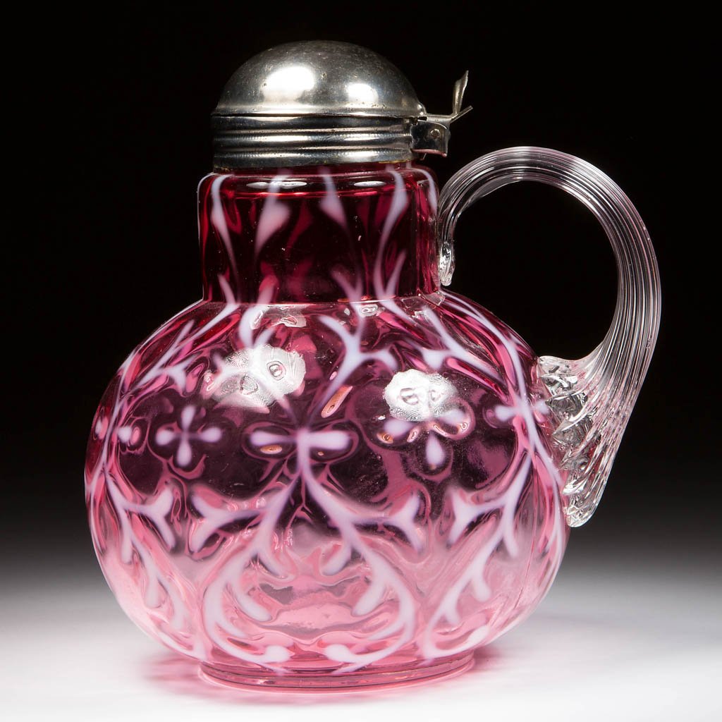 OPALINE BROCADE / SPANISH LACE SYRUP PITCHER: OPALINE BROCADE / SPANISH LACE SYRUP PITCHER, cranberry opalescent, applied colorless reeded handle, period lid. Northwood Glass Co. Circa 1899. 5 3/4" HOA. Literature: Parallels Heacock/Elmore - Opal