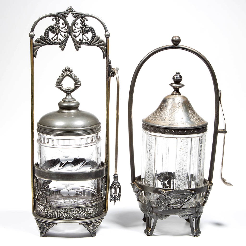 VICTORIAN PRESSED GLASS PICKLE CASTERS, LOT OF TWO: VICTORIAN PRESSED GLASS PICKLE CASTERS, LOT OF TWO, colorless inserts, one with engraved floral decoration, each fitted in a quadruple-plate stand, one marked for Reed & Barton and with coin silver la