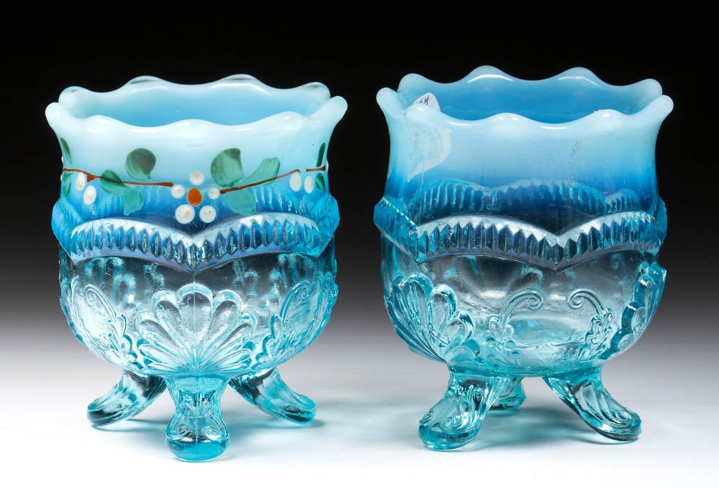 MANILA / WREATH AND SHELL TOOTHPICK HOLDERS, LOT OF TWO: MANILA / WREATH AND SHELL TOOTHPICK HOLDERS, LOT OF TWO, blue opalescent, one with polychrome decoration. Model Flint Glass Co. Circa 1899-1903. 2 1/4" H. Literature: Parallels Heacock/Elmore - Opales