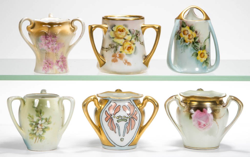 R. S. GERMANY PORCELAIN TOOTHPICK HOLDERS, LOT OF SIX: R. S. GERMANY PORCELAIN TOOTHPICK HOLDERS, LOT OF SIX, each with three handles, hand-painted and transfer printed decorations, green and teal wreath marks. First quarter 20th century. 2 1/4" to 2 3/4"