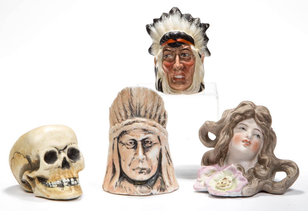 ASSORTED BISQUE FIGURAL TOOTHPICK HOLDERS, LOT OF FOUR: ASSORTED BISQUE FIGURAL TOOTHPICK HOLDERS, LOT OF FOUR, comprising two Native American, a Maiden, and a Skull example. Late 19th/early 20th century. 2" to 3" H. Provenance: The Lowell Wiggins collecti