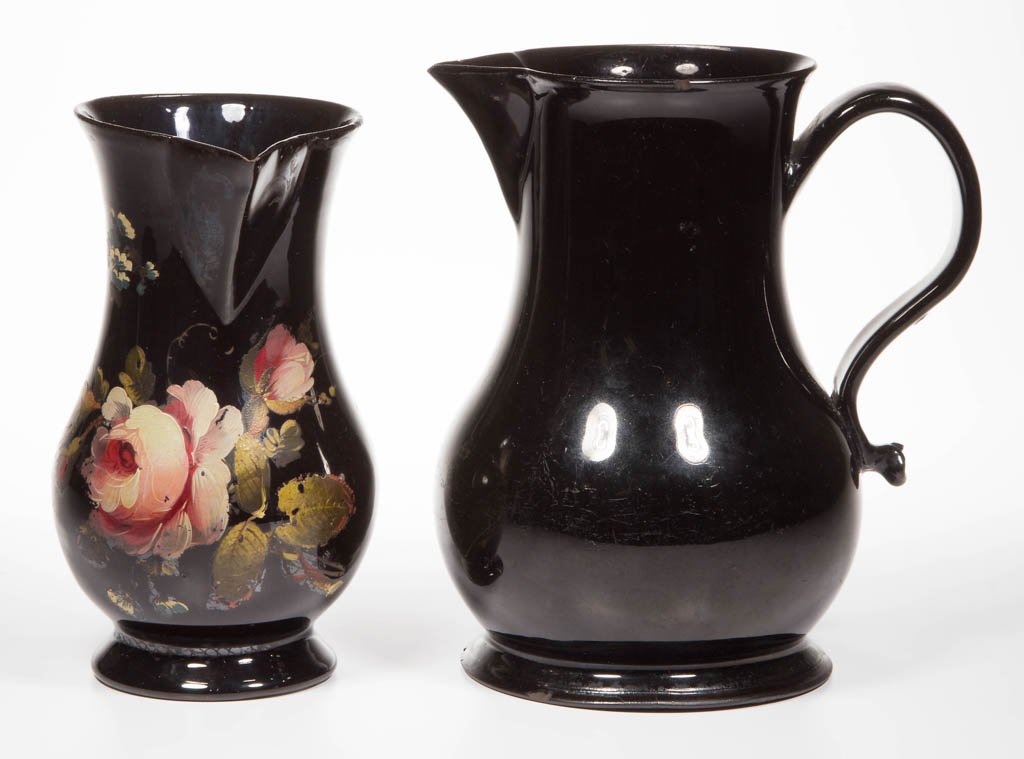 ENGLISH STAFFORDSHIRE POTTERY BLACK-GLAZED RED: ENGLISH STAFFORDSHIRE POTTERY BLACK-GLAZED RED EARTHENWARE PITCHERS, LOT OF TWO, both Jackfield-type jugs of pear form, with sparrow-beak spouts and wide strap handles, the smaller example painted in