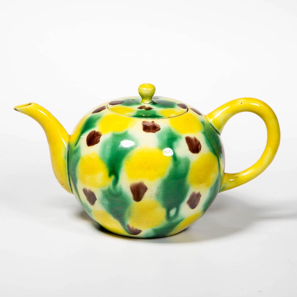 ENGLISH STAFFORDSHIRE POTTERY CREAMWARE YELLOW-GLAZED: ENGLISH STAFFORDSHIRE POTTERY CREAMWARE YELLOW-GLAZED TEAPOT AND COVER, of globular form, with rounded C-form handle and molded spout, the lightly domed lid with globular knop; painted with manganese