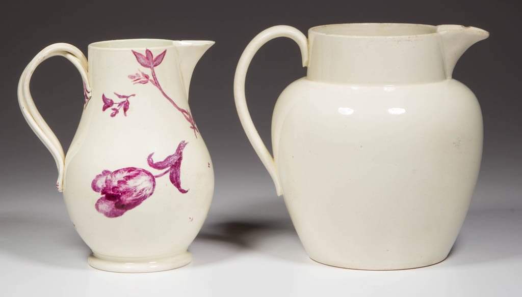 ENGLISH STAFFORDSHIRE POTTERY CREAMWARE PITCHERS, LOT: ENGLISH STAFFORDSHIRE POTTERY CREAMWARE PITCHERS, LOT OF TWO, comprising an undecorated cider jug of Dutch shape, and a cream jug with entwined, grooved strap handles with foliate terminates, printed