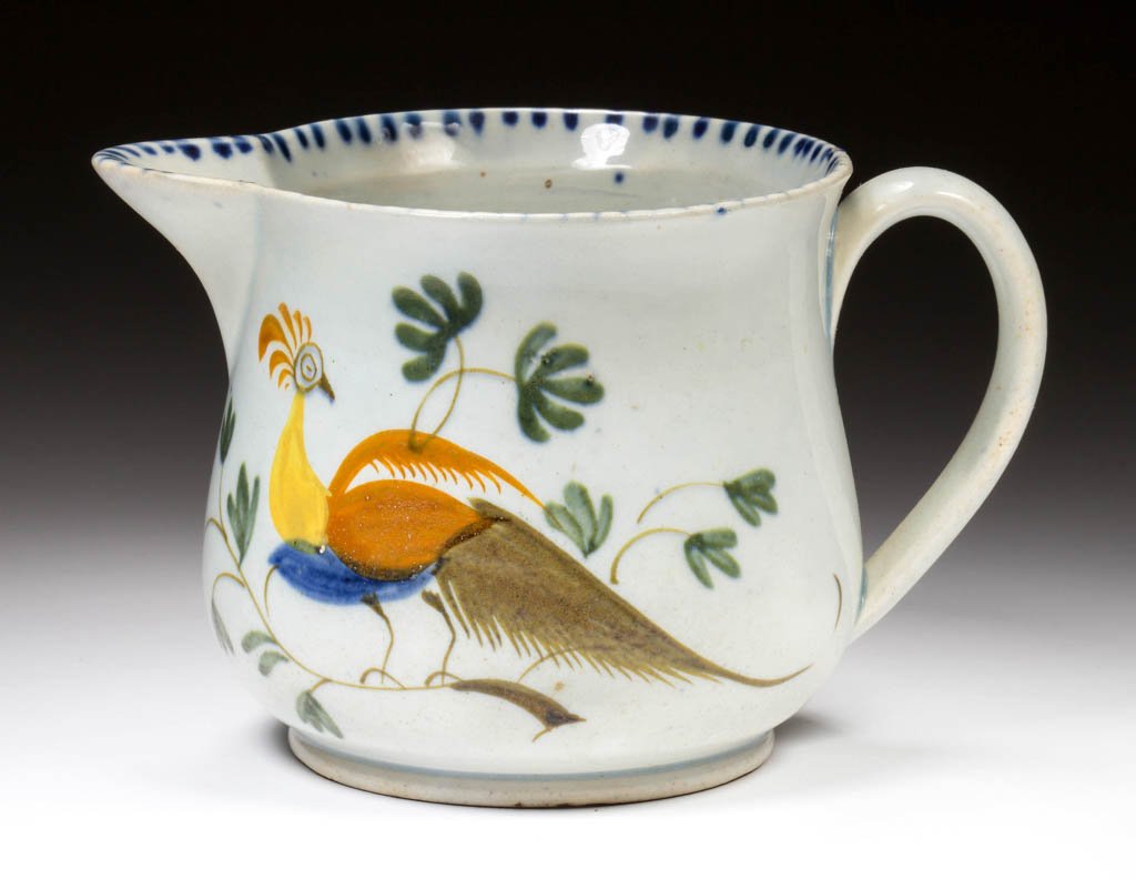 ENGLISH STAFFORDSHIRE POTTERY PEARLWARE PEAFOWL SQUAT: ENGLISH STAFFORDSHIRE POTTERY PEARLWARE PEAFOWL SQUAT PITCHER, of pear form, painted with a band of blue dashes to upper rim, one side of the body with large peafowl perched on brown branches among st