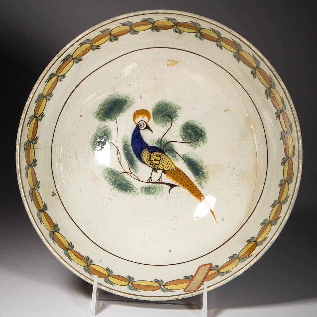 ENGLISH STAFFORDSHIRE POTTERY PEARLWARE PEAFOWL PUNCH: ENGLISH STAFFORDSHIRE POTTERY PEARLWARE PEAFOWL PUNCH BOWL ON FOOT, the exterior painted with a wide band of stylized foliate and fish-scale motifs in typical Prattware hues of ocher, brown, green and