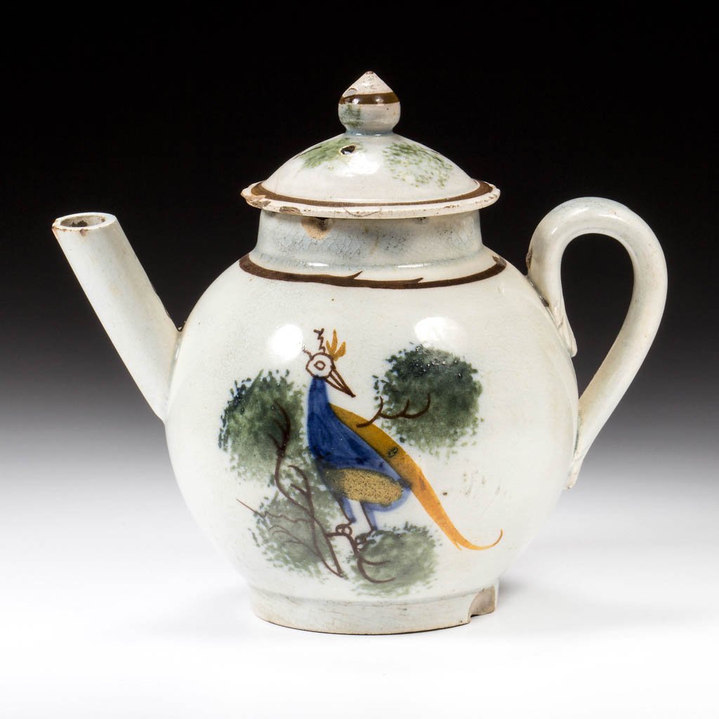 ENGLISH STAFFORDSHIRE POTTERY PEARLWARE PEAFOWL TOY: ENGLISH STAFFORDSHIRE POTTERY PEARLWARE PEAFOWL TOY TEAPOT AND COVER, of globular form on foot, with strap handle and straight spout, the cover with applied onion-form knop, painted in typical Prattwa