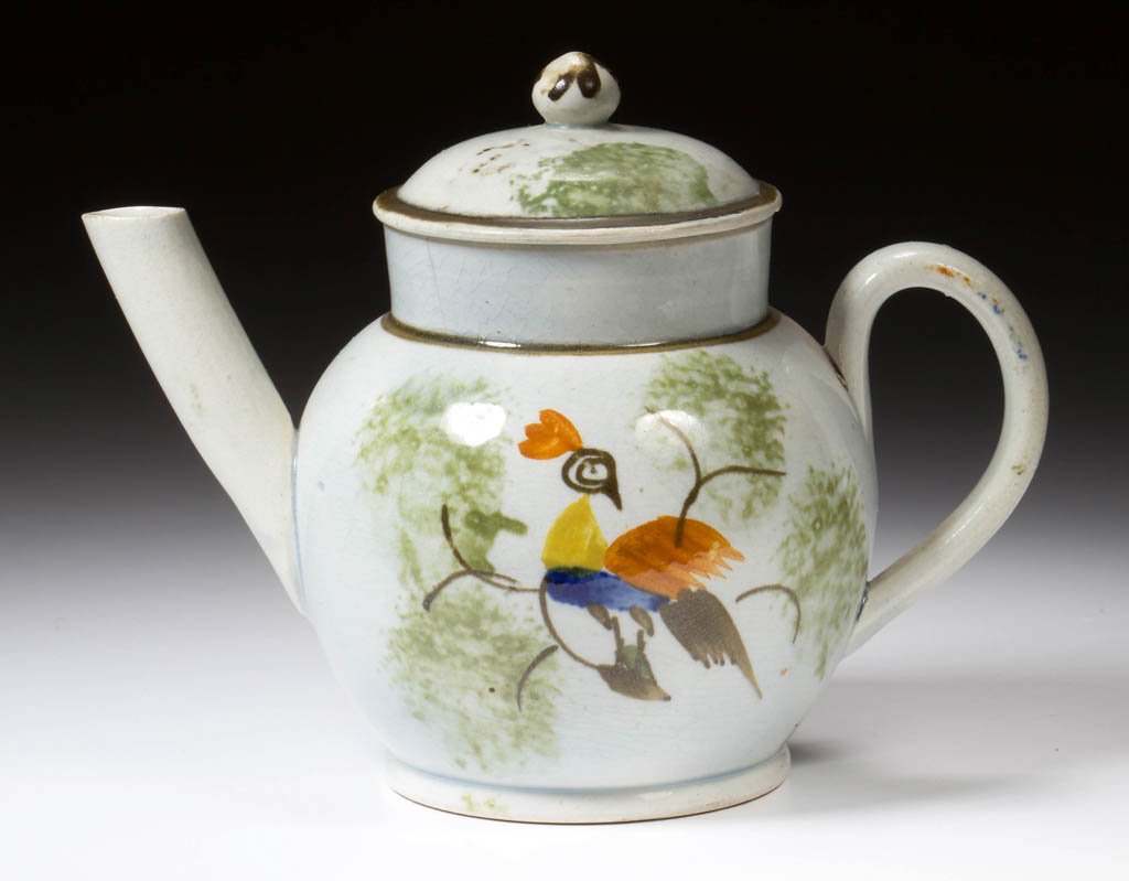ENGLISH STAFFORDSHIRE POTTERY PEARLWARE PEAFOWL TOY: ENGLISH STAFFORDSHIRE POTTERY PEARLWARE PEAFOWL TOY TEAPOT AND COVER, of globular form with strap handle and straight spout, the cover with applied onion-form knop, painted in typical Prattware hues w