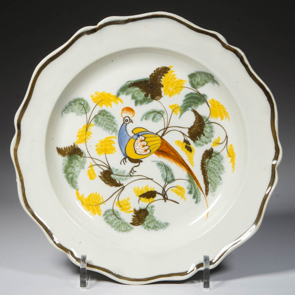 ENGLISH STAFFORDSHIRE POTTERY PEARLWARE PEAFOWL PLATE: ENGLISH STAFFORDSHIRE POTTERY PEARLWARE PEAFOWL PLATE, press-molded with a lobed rim, the edge decorated with a brown band, the face painted with a long-tailed peafowl in blue, yellow, orange and brow