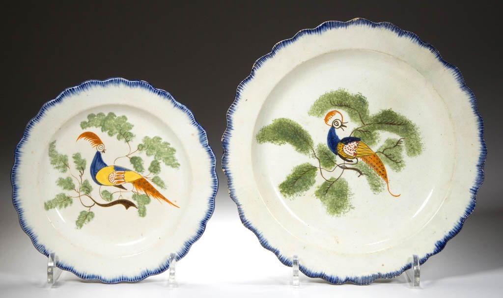 ENGLISH STAFFORDSHIRE POTTERY PEARLWARE PEAFOWL PLATES,: ENGLISH STAFFORDSHIRE POTTERY PEARLWARE PEAFOWL PLATES, LOT OF TWO, of differing size, with press-molded scallop-shell rims, painted with a band of cobalt blue to the edge, the face painted with a lon