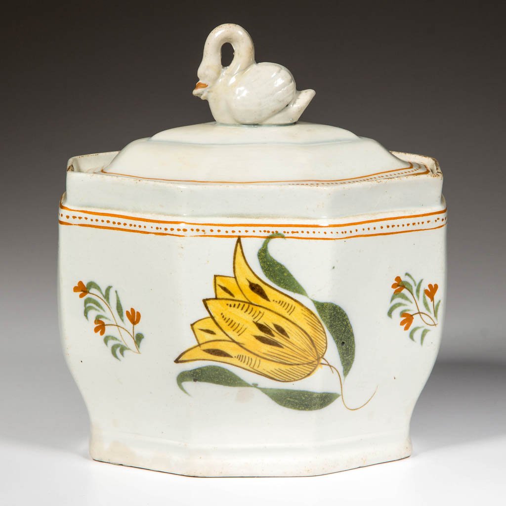 ENGLISH STAFFORDSHIRE POTTERY PEARLWARE SUGAR BOX AND: ENGLISH STAFFORDSHIRE POTTERY PEARLWARE SUGAR BOX AND COVER, of oblong, octagonal form, the stepped cover with swan-form knop, painted in typical Prattware hues with a single large, stylized tulip and