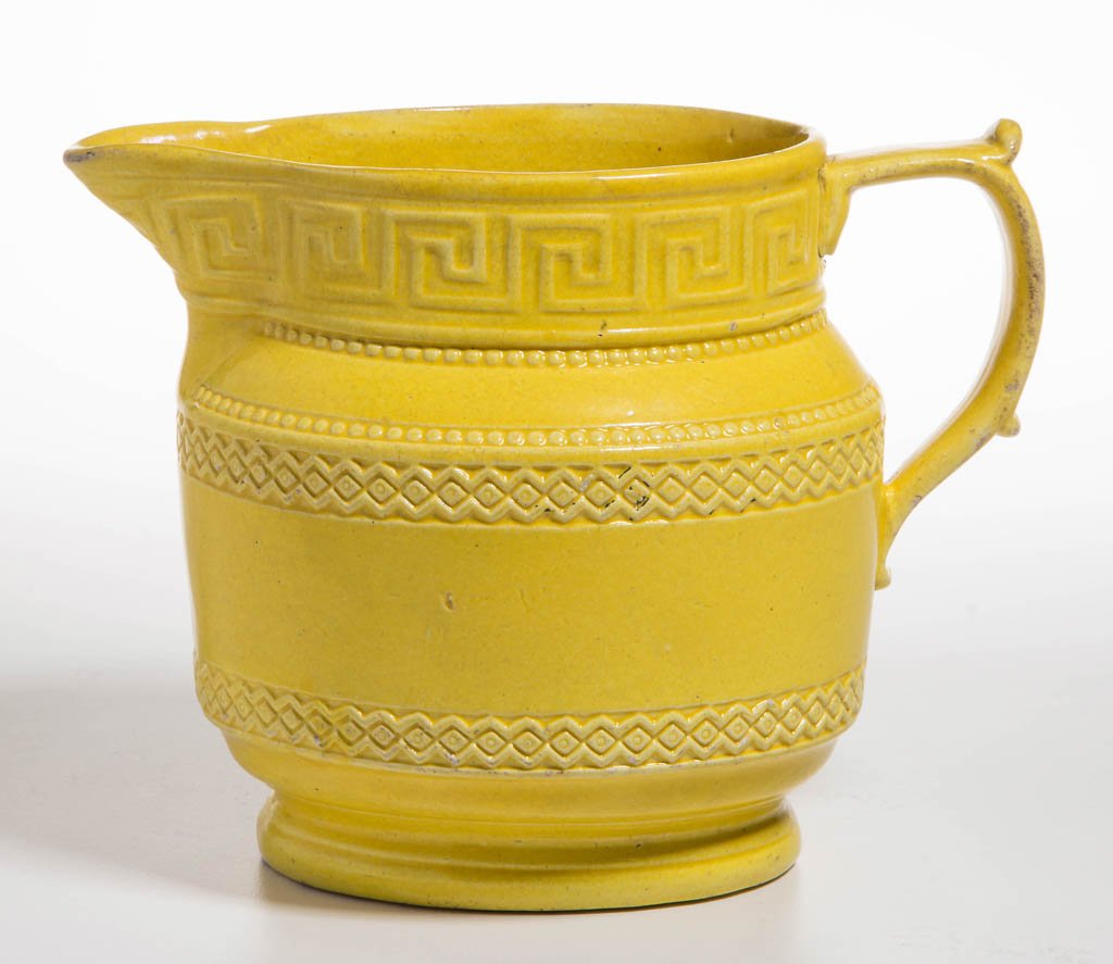 ENGLISH STAFFORDSHIRE POTTERY PEARLWARE YELLOW PITCHER: ENGLISH STAFFORDSHIRE POTTERY PEARLWARE YELLOW PITCHER, of ovate form with thumb- and pinky-rests to handle, molded with straight cylindrical panel to waist, the neck molded with Greek key design abov