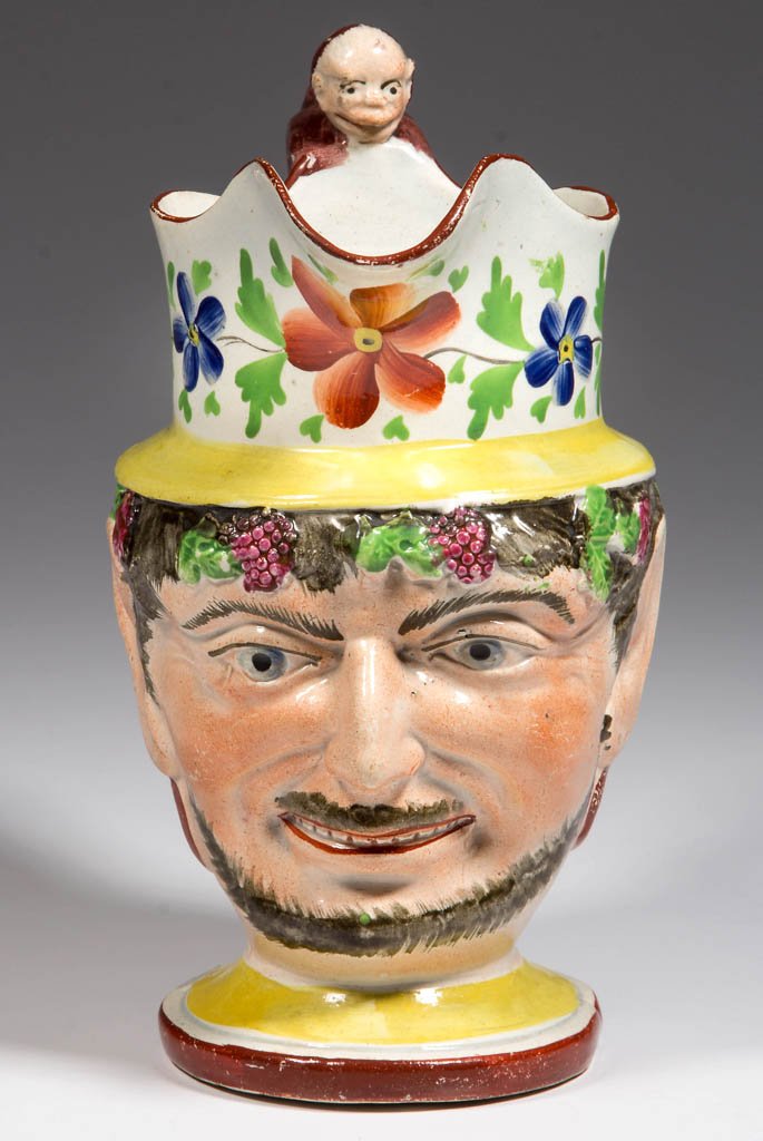 ENGLISH STAFFORDSHIRE POTTERY PEARLWARE YELLOW-GROUND: ENGLISH STAFFORDSHIRE POTTERY PEARLWARE YELLOW-GROUND BACCHUS PITCHER, of baluster form, the undulating rim over a high neck, the body in the form of Bacchus' head, molded with grape clusters and leav