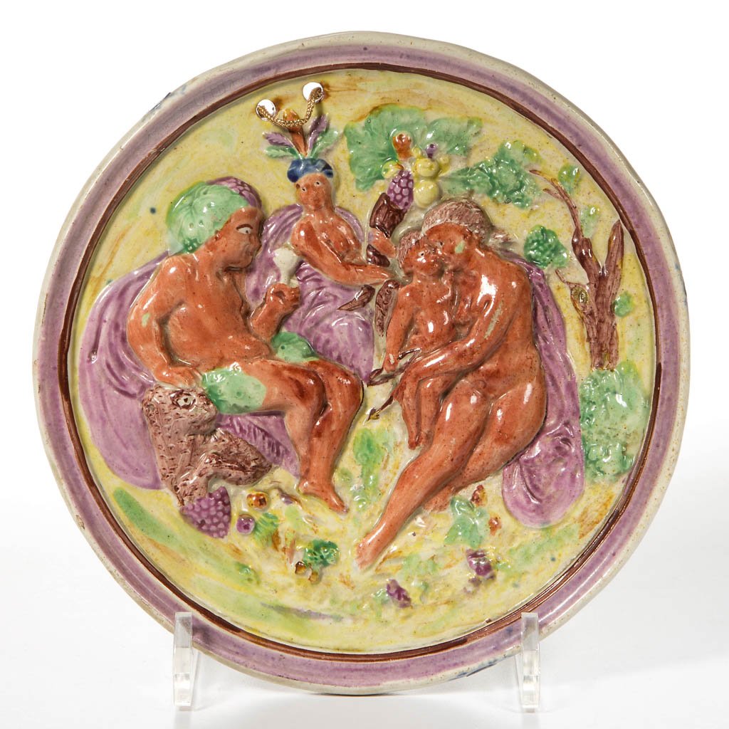 ENGLISH DURHAM OR YORKSHIRE POTTERY PEARLWARE CANARY: ENGLISH DURHAM OR YORKSHIRE POTTERY PEARLWARE CANARY YELLOW CIRCULAR PLAQUE, with a step-molded rim, the center press-molded in low relief with Bacchus drinking wine with nymphs in a rural setting, on