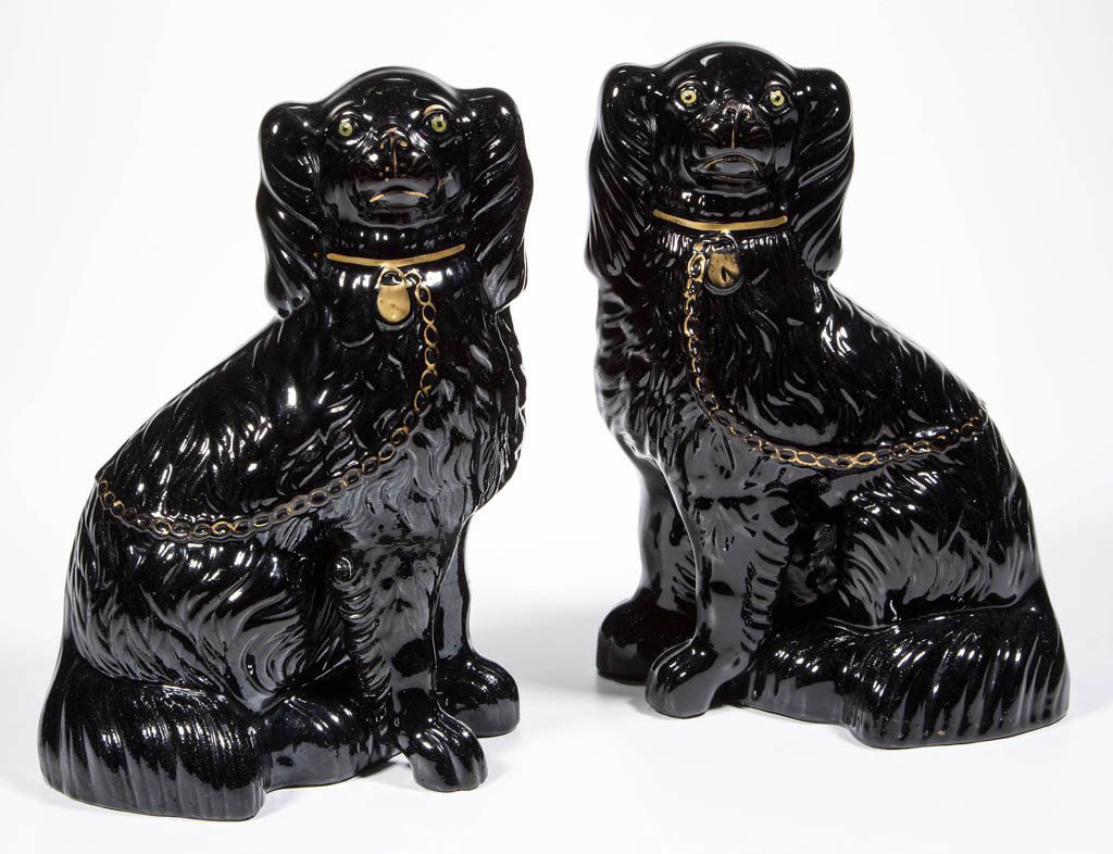 ENGLISH STAFFORDSHIRE POTTERY BLACK-GLAZED REDWARE: ENGLISH STAFFORDSHIRE POTTERY BLACK-GLAZED REDWARE SPANIELS, PAIR, molded as seated dogs facing each other, each with gold-lustered collar, lock and chain-form leash, with yellow-green eyes. Unmarked.