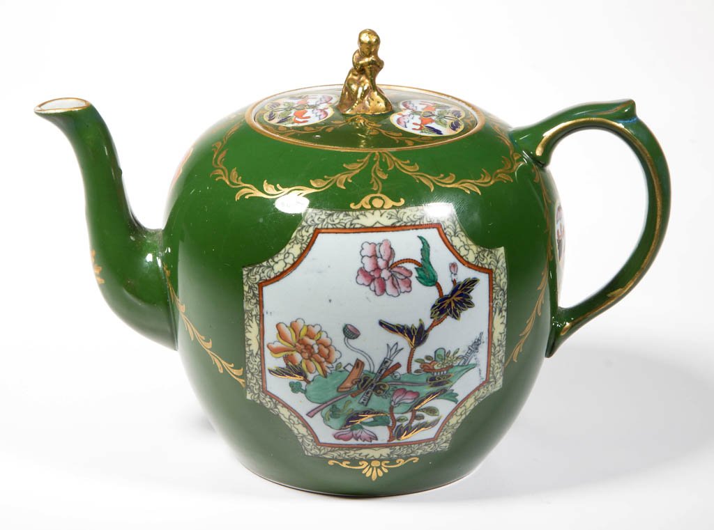 ENGLISH IRONSTONE POTTERY GREEN-GROUND TEAPOT AND COVER: ENGLISH IRONSTONE POTTERY GREEN-GROUND TEAPOT AND COVER, of ovate form, the handle with thumb rest, and the spout with mild S-form, the nearly-flat cover with applied knop modeled as the figure of boy