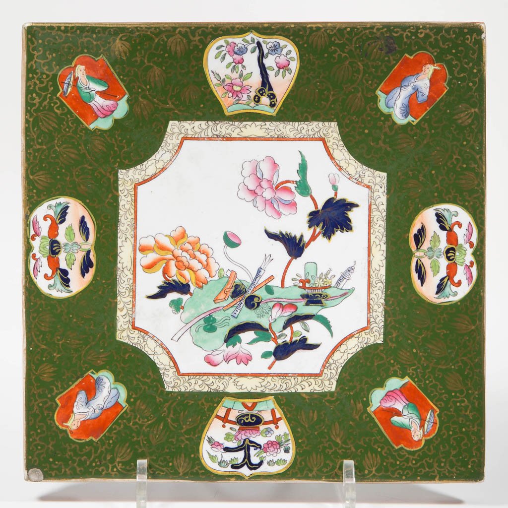 ENGLISH ASHWORTH POTTERY GREEN-GROUND SQUARE TRIVET ON: ENGLISH ASHWORTH POTTERY GREEN-GROUND SQUARE TRIVET ON FOOT, of tile-form, on squat, rounded feet, printed and overpainted with gilt foliate motifs over all, surrounding and above Chinese-style reserv