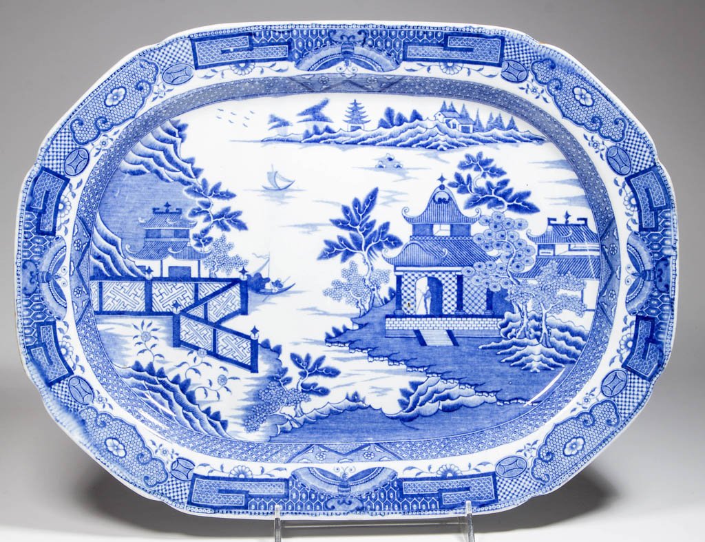 ENGLISH STAFFORDSHIRE POTTERY PEARLWARE "BRIDGELESS: ENGLISH STAFFORDSHIRE POTTERY PEARLWARE "BRIDGELESS CHINOISERIE" PLATTER, of canted-corner and lobed rectangular form, transfer-printed in medium blue with the Fitzhugh border with butterfly variation