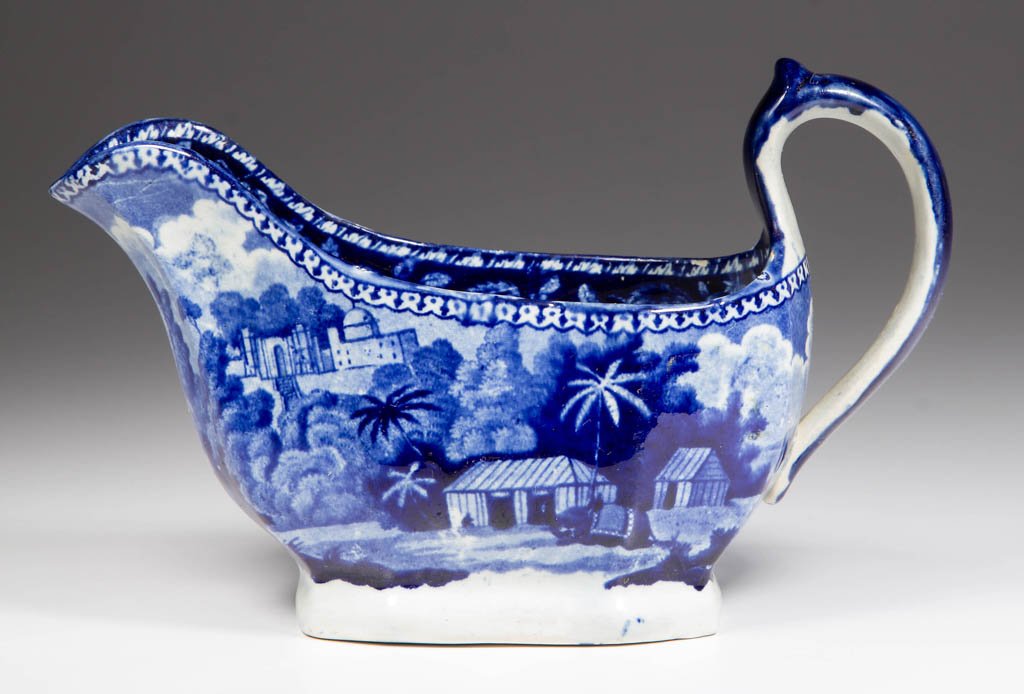 ENGLISH JOHN HALL POTTERY PEARLWARE "SICRE GULLY PASS": ENGLISH JOHN HALL POTTERY PEARLWARE "SICRE GULLY PASS" PATTERN SAUCEBOAT, of low, ovate, multi-paneled form, with up-arching handle, transfer-printed in dark blue with the pattern to the exterior, wit