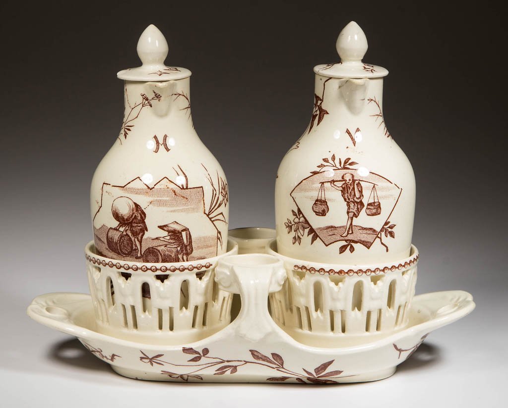 FRENCH LUNEVILLE POTTERY KELLER & GUERIN CREAMWARE: FRENCH LUNEVILLE POTTERY KELLER & GUERIN CREAMWARE CRUET SET, LOT OF THREE, comprising a boat-shaped stand, molded with pierced handles, the center molded with two shaped pierced bottle stands, holdin