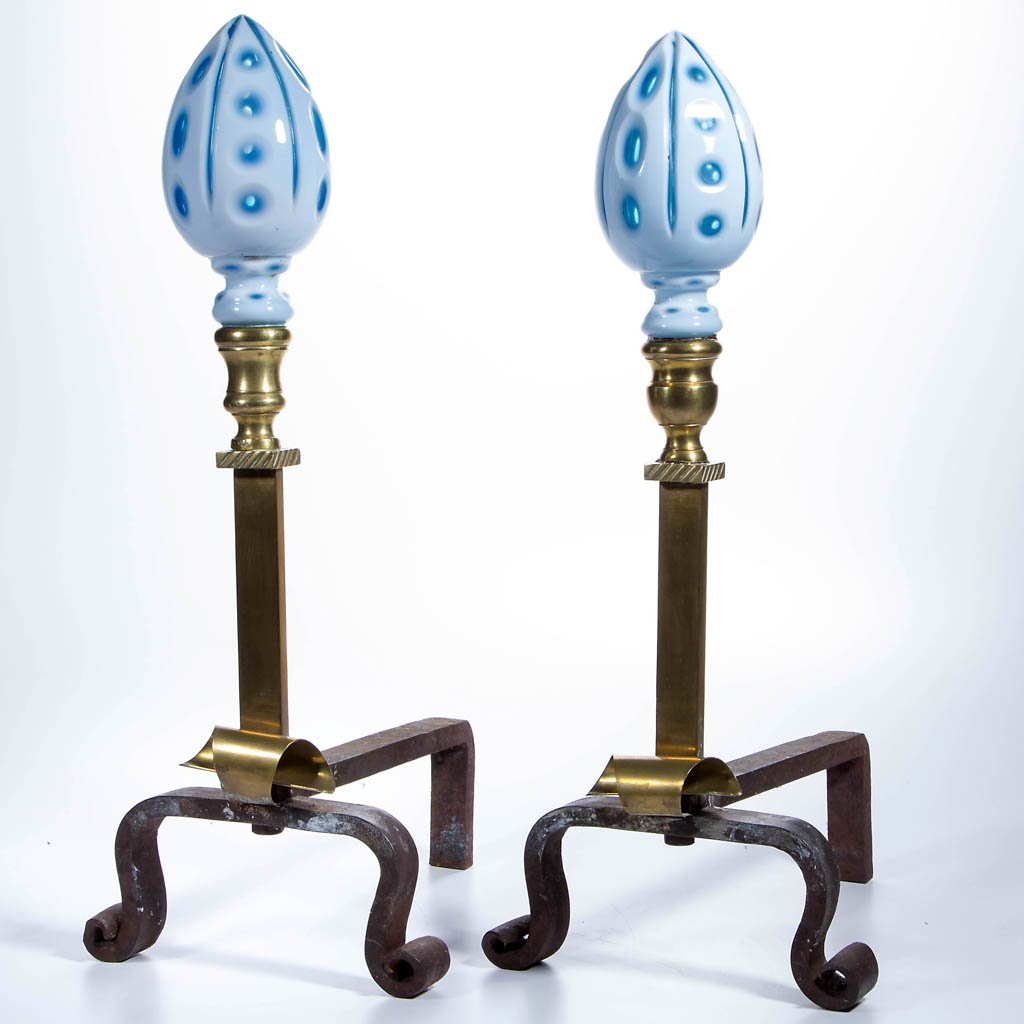 PAIR OF HAND-CRAFTED ANDIRONS: PAIR OF HAND-CRAFTED ANDIRONS, each with cut overlay glass finials above a brass standard raised on wrought-iron legs with scrolled feet. 20th century. 20 1/2" HOA, 13" LOA. Provenance: Property from 