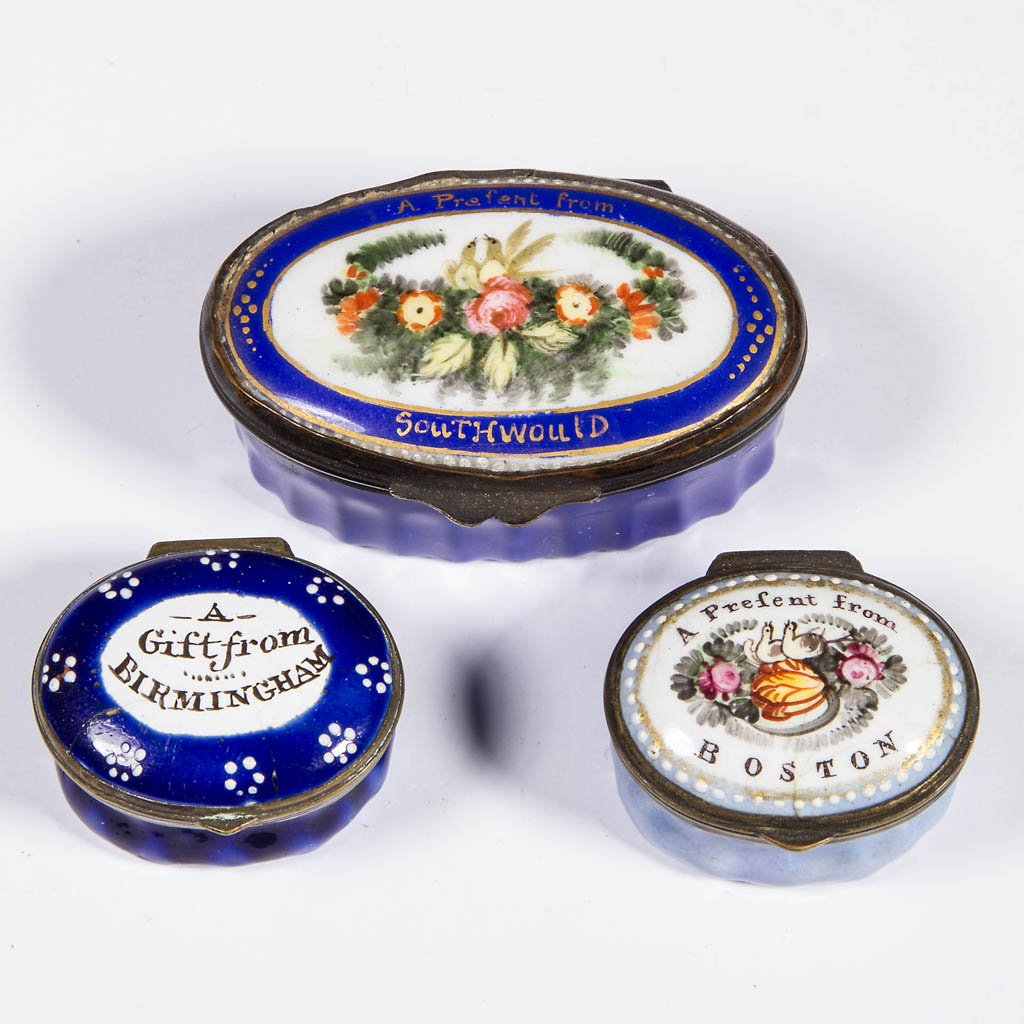 BATTERSEA / BILSTON ENAMEL SNUFF / PILL BOXES, LOT OF: BATTERSEA / BILSTON ENAMEL SNUFF / PILL BOXES, LOT OF THREE, each of oval form with hinged lid, featuring gift or present inscriptions from Boston, Birmingham, and Southwould, two smallest with mirror