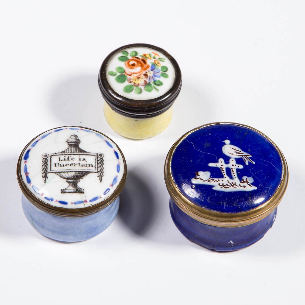 BATTERSEA / BILSTON ENAMEL PILL BOXES, LOT OF THREE: BATTERSEA / BILSTON ENAMEL PILL BOXES, LOT OF THREE, each of circular form with lift-off lid, one with urn inscribed "Life is Uncertain", one cobalt with white birds, and one with floral decoration, o