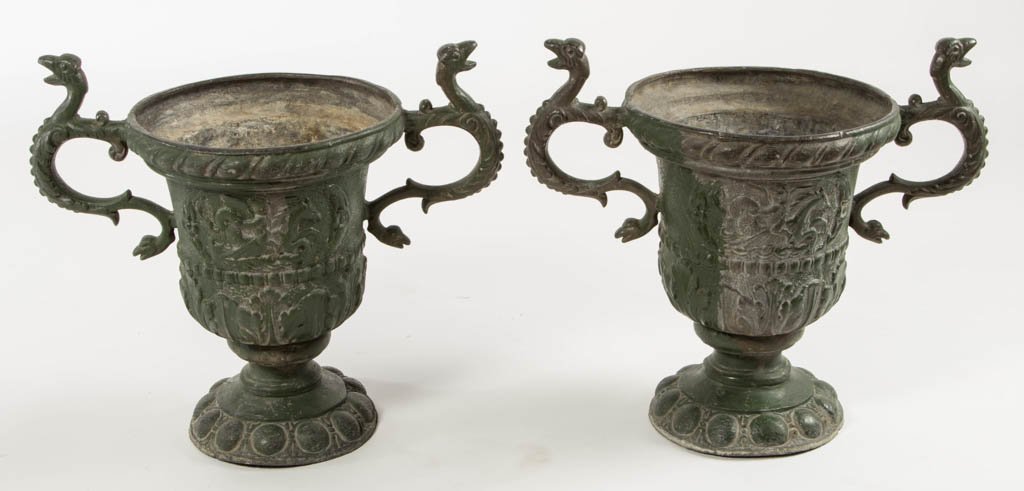 PAIR OF ENGLISH NEOCLASSICAL-STYLE CAST-LEAD GARDEN: PAIR OF ENGLISH NEOCLASSICAL-STYLE CAST-LEAD GARDEN URNS, each with scrolled handles and footed base. Design featuring winged cherub riding mythical seahorse figure. Old green-painted surface. 19th/20