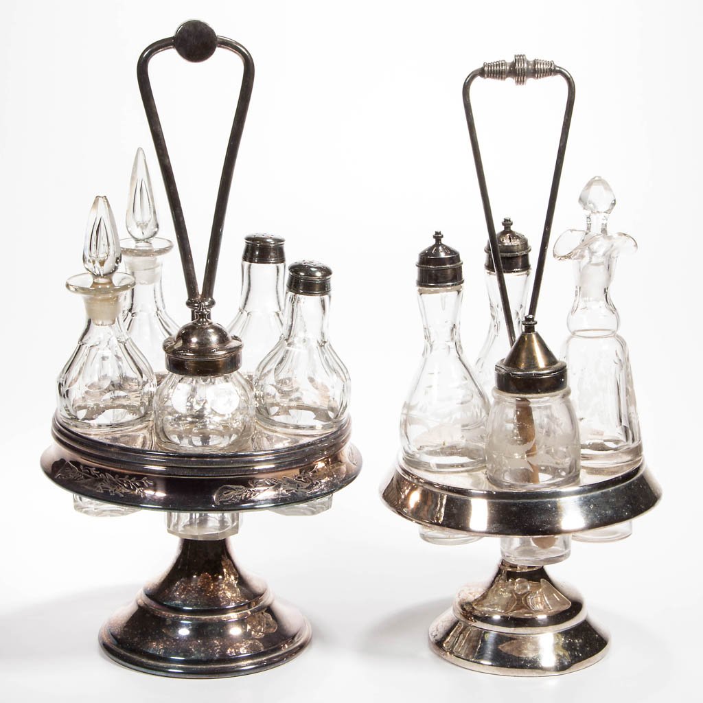 VICTORIAN SILVER-PLATED AND GLASS CASTER SETS, LOT OF: VICTORIAN SILVER-PLATED AND GLASS CASTER SETS, LOT OF TWO, four- and five-bottle examples, each with a swivel stand. Fourth quarter 19th century. 14" and 15" HOA. Provenance: Property of a New England
