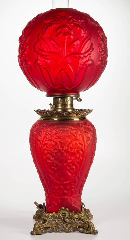 VICTORIAN GONE-WITH-THE-WIND PARLOR LAMP: VICTORIAN GONE-WITH-THE-WIND PARLOR LAMP, ruby satin, lamp consists of a Pittsburgh Double Dolphin base with original cast-iron decorative foot and decorative cast-iron font crown, together by associa