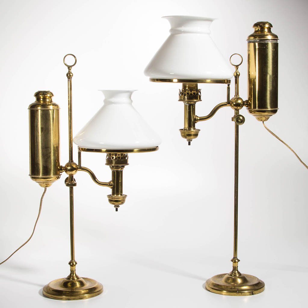 PAIR OF SINGLE-ARM BRASS STUDENT LAMPS: PAIR OF SINGLE-ARM BRASS STUDENT LAMPS, each with an adjustable horizontal tank on a central shaft and weighted base. Each shade ring and font holder with patent information, each comes with a milk gl