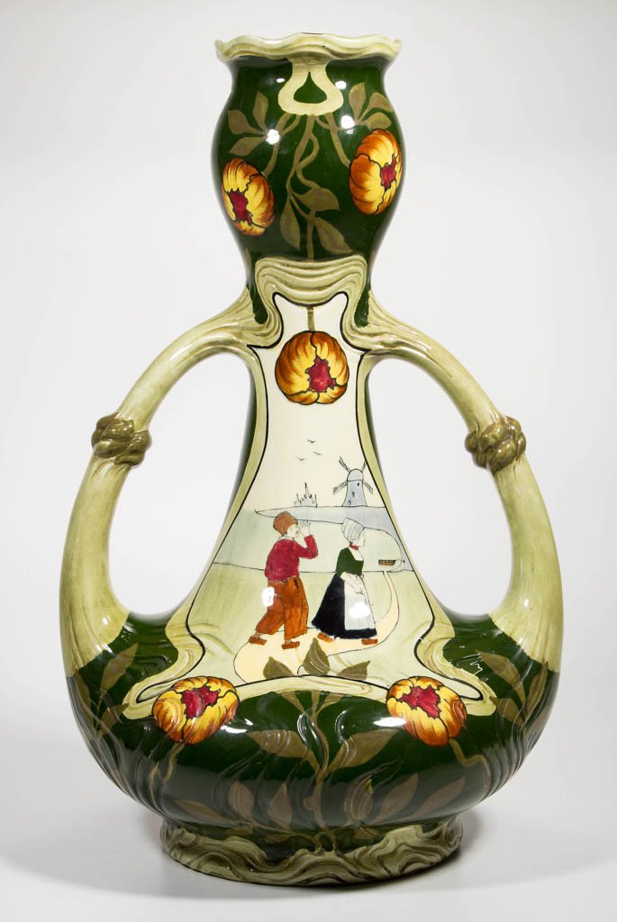 CONTINENTAL ARTS & CRAFTS ART POTTERY VASE: CONTINENTAL ARTS & CRAFTS ART POTTERY VASE, with substantial double handles, bulbous base tapering to narrow neck, widening at top, with scalloped rim, decorated with scattered tulip blossoms and cent