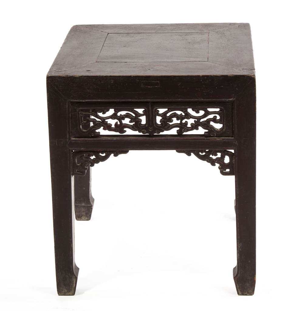 CHINESE CARVED HARDWOOD SIDE TABLE: CHINESE CARVED HARDWOOD SIDE TABLE, probably teak, on straight legs, with carved open-work panels to each side, above similar corner brackets. Original red lacquer finish partially visible under later