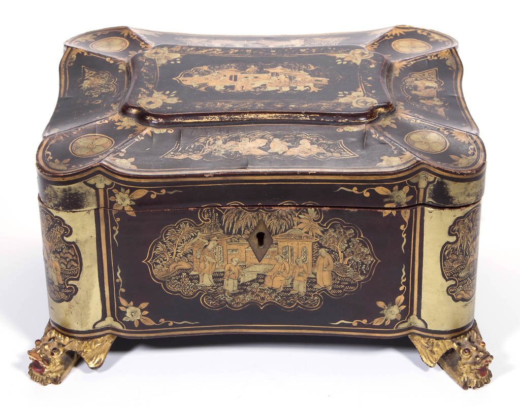 CHINOISERIE LACQUERED TEA CADDY: CHINOISERIE LACQUERED TEA CADDY, black and gold painted, rectangular, lobed form, with hinged lid, on figural dragon or Kirin feet, the cover with concave panels mirroring the lobed body, centering a