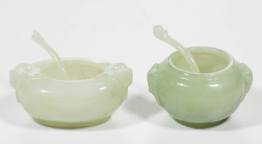 CHINESE JADE SALT CELLARS, LOT OF TWO: CHINESE JADE SALT CELLARS, LOT OF TWO, one of nearly of nearly white hue, of oval form, carved with mask-head handles to either side and the other of darker hue, also with mask-head handles, of globul