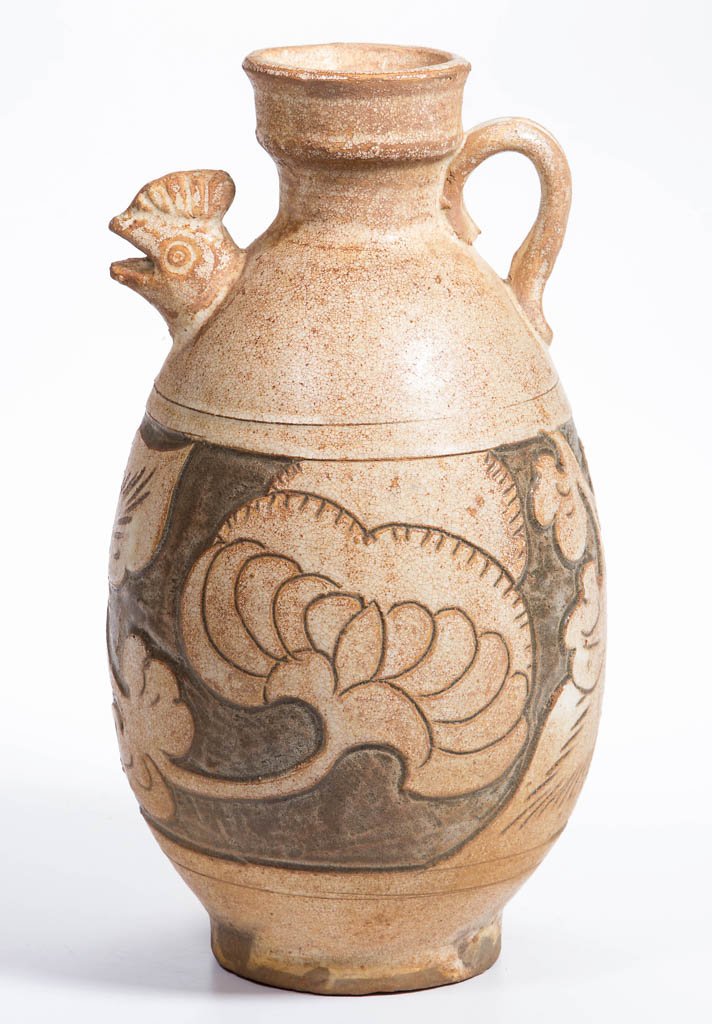 CHINESE EARTHENWARE FOOTED JUG / EWER: CHINESE EARTHENWARE FOOTED JUG / EWER, Song style, ovoid form, with cup-form mouth, applied single-grooved handle, and figural chicken- or fish-head spout, the body with a broad sgrafitto band of blos