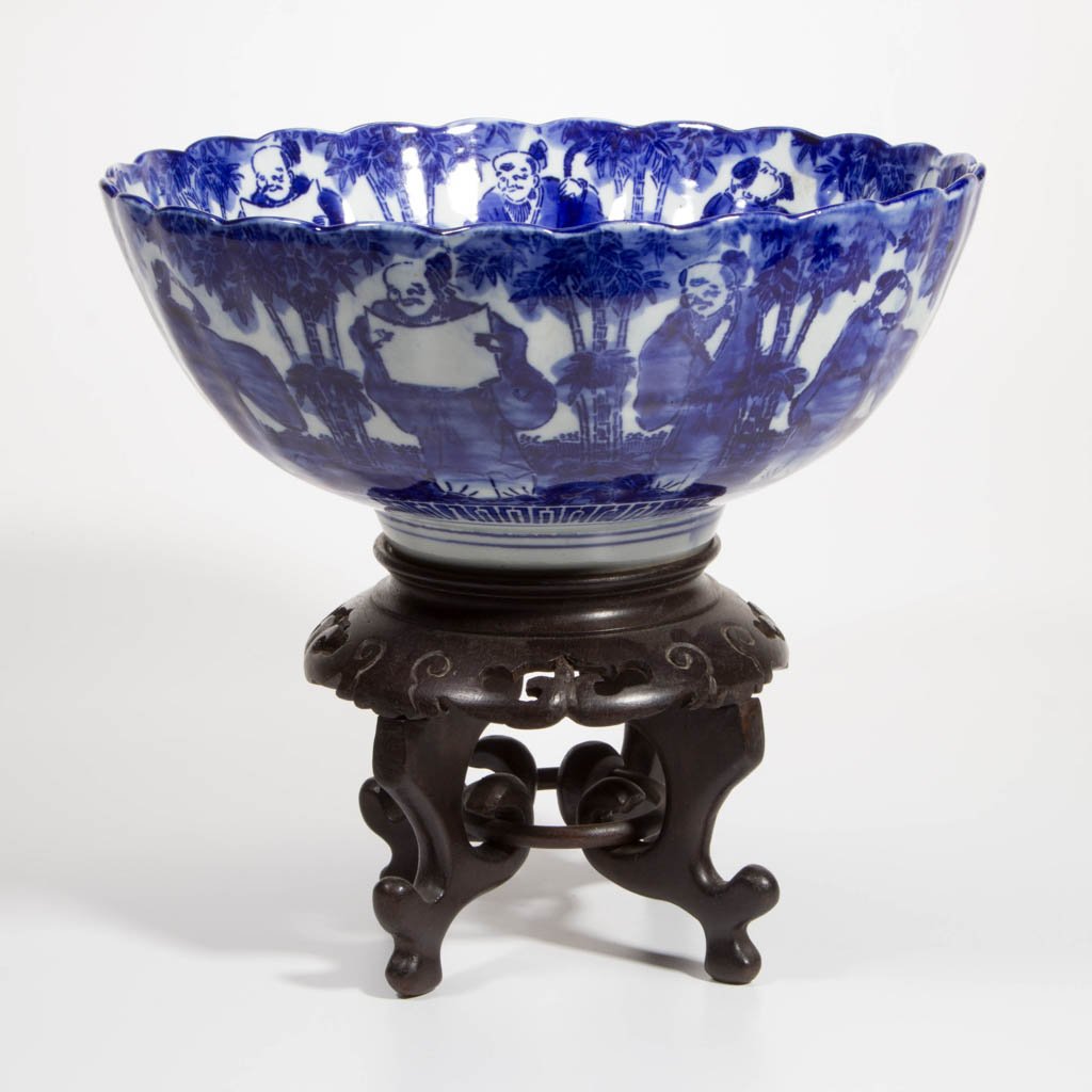 JAPANESE BLUE AND WHITE PORCELAIN BOWL: JAPANESE BLUE AND WHITE PORCELAIN BOWL, with scalloped rim corresponding to lobed form, on foot, with deep underside-well; printed with scene of scholars in a bamboo grove, full round, exterior and in