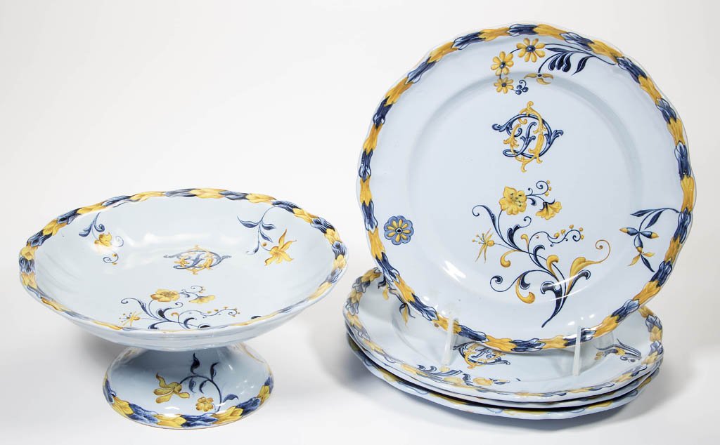 EMILE GALLE, NANCY, FRANCE FAIENCE POTTERY TABLE: EMILE GALLE, NANCY, FRANCE FAIENCE POTTERY TABLE ARTICLES, LOT OF FIVE, comprising a compote and four matching plates, each with blue and yellow floral decoration, and monogram. Signed in underglaze-b