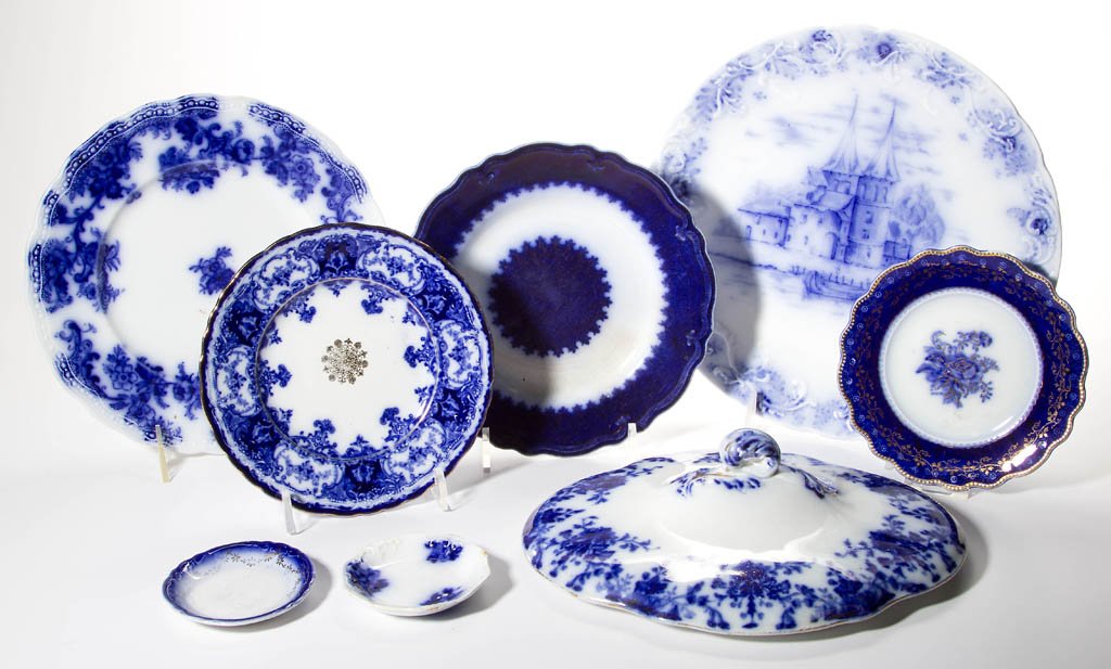 ASSORTED FLOW BLUE ARTICLES, LOT OF EIGHT: ASSORTED FLOW BLUE ARTICLES, LOT OF EIGHT, including a Maddock & Sons plate, a W. H. Grindley & Co. plate, a New Wharf Pottery plate, and a tureen cover attributed to Ridgway. Mid to late 19th century